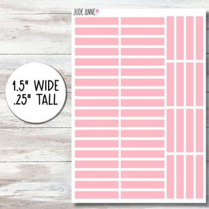 May include: Sheet of pink and white planner stickers. The stickers are rectangular, 1.5 inches wide and .25 inches tall. The sheet also includes vertical pink and white stickers. The brand name "Jude Anne" is in the top right corner.