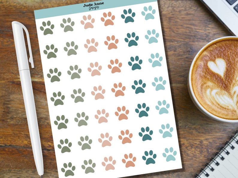 May include: A sheet of paw print stickers in various shades of green, blue, and pink. The stickers are arranged in rows and columns on a white background.