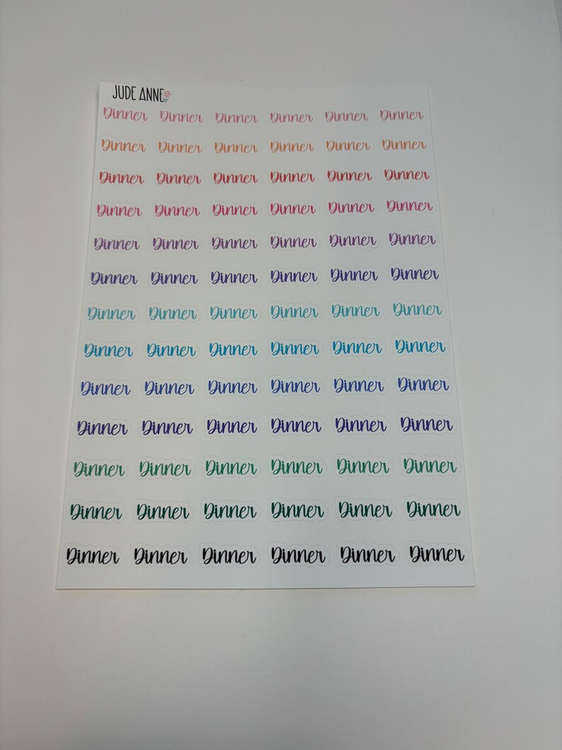 May include: A sheet of colorful stickers with the word "Dinner" written on each sticker. The stickers are arranged in rows of six.