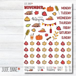 May include: A sticker sheet with a Thanksgiving theme. It features illustrations of pumpkins, leaves, turkey, pie, and a coffee cup. The sheet includes the month of November, days of the week, and numbered leaf stickers for the calendar.