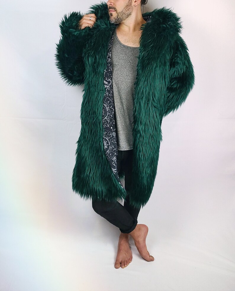May include: A long, dark green faux fur coat with a hood. The lining of the coat is a black and white print of a celestial design.