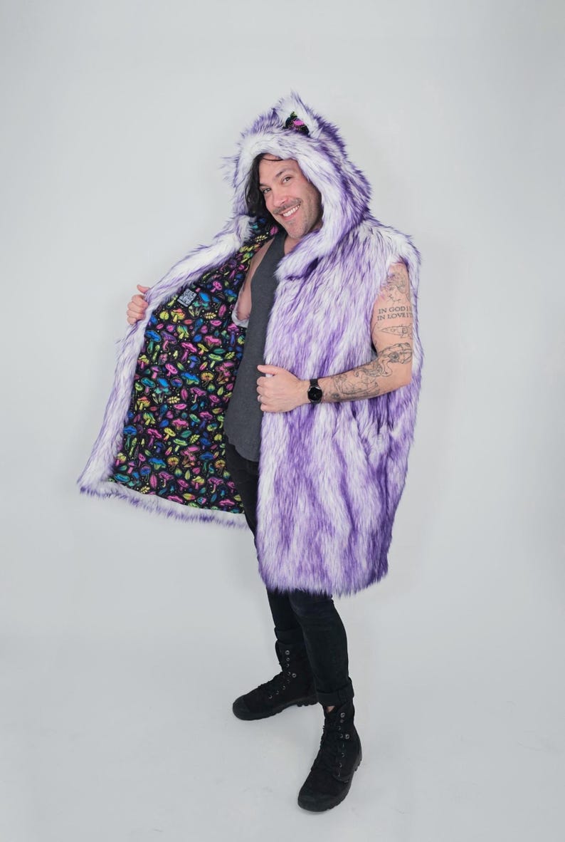 May include: A sleeveless faux fur vest featuring a purple and white gradient pattern with an attached hood. The interior lining is black and decorated with a colorful, repeating pattern of various mushrooms in shades of pink, yellow, and blue.