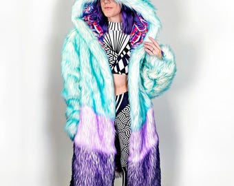 May include: A long, hooded faux fur coat with a gradient of blue, purple and white. The hood is lined with white faux fur.