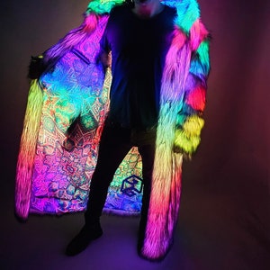 May include: A person wearing a rainbow-colored faux fur coat with a white lining. The coat is illuminated with LED lights, creating a vibrant and colorful effect.
