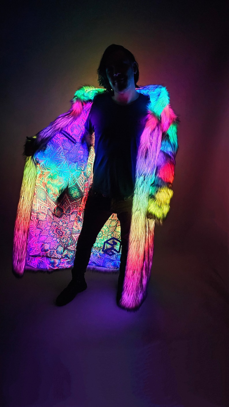 May include: A person wearing a rainbow-colored faux fur coat with a white lining. The coat is illuminated with LED lights, creating a vibrant and colorful effect.