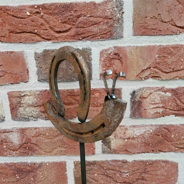 Snail made of horseshoe as garden decoration in shabby chic
