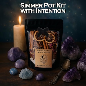 Può includere: Un sacchetto nero con l'etichetta "Simmer Pot Kits With Intention" pieno di piante essiccate, bastoncini di cannella e anice stellato. Il sacchetto è legato con un fiocco nero e si trova tra cristalli di ametista, una candela accesa e un cucchiaio vintage. È visibile anche il testo "Ravenveil & Co.".