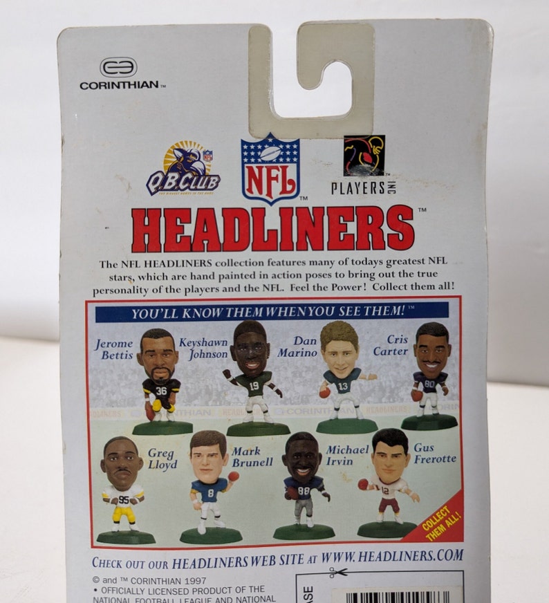 May include: A colorful cardboard backer for a set of NFL Headliners collectible figurines. The backer features a red, white, and blue color scheme with the NFL logo and the words "Headliners" in large, bold letters. The backer also features images of eight different NFL players, including Jerome Bettis, Keyshawn Johnson, Dan Marino, Cris Carter, Greg Lloyd, Mark Brunell, Michael Irvin, and Gus Frerotte.