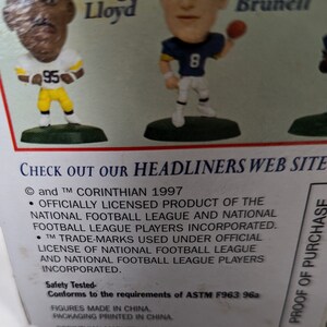 May include: A close-up of a product box featuring two NFL football player figurines. The box is green and white with the text "CHECK OUT OUR HEADLINERS WEB SITE" and "PROOF OF PURCHASE". The text "and TM CORINTHIAN 1997" is also visible on the box.
