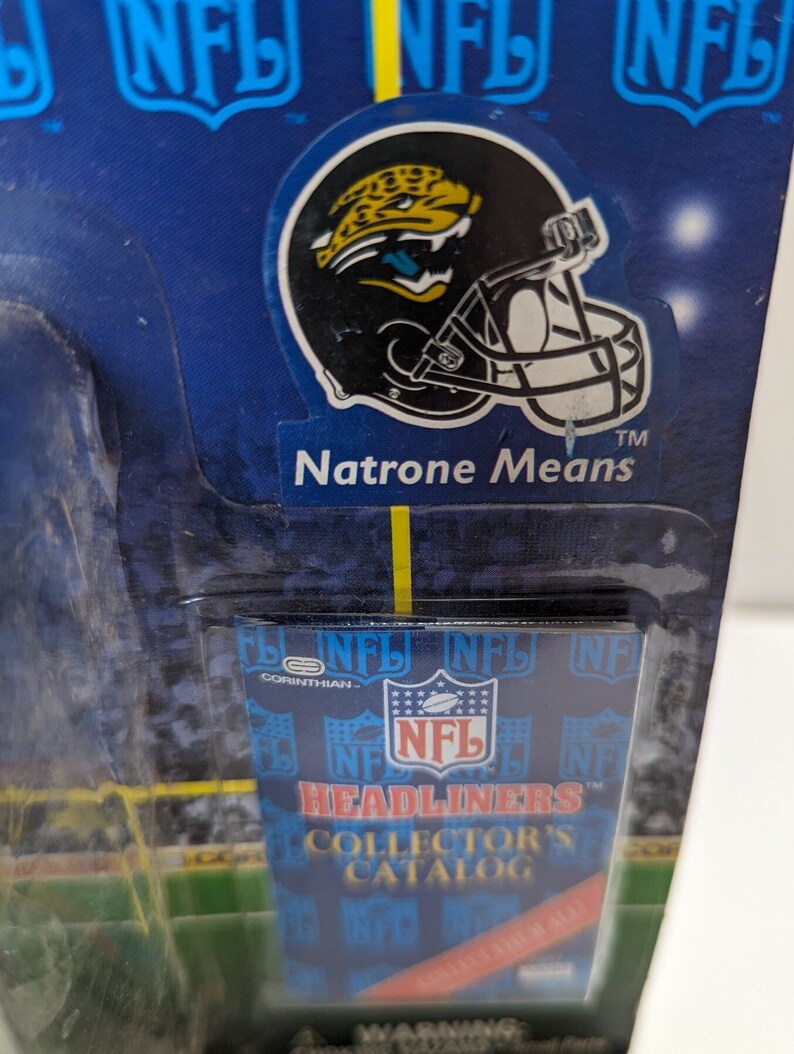 May include: A blue and white NFL Headliners Collector's Catalog card with a black and yellow Jacksonville Jaguars helmet sticker featuring a jaguar. The sticker reads "Natrone Means" and "TM".