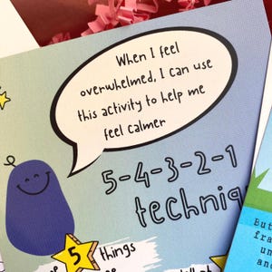 Puede incluir: Un personaje de dibujos animados azul con una estrella en la cabeza y el texto "5 cosas" debajo. El texto en un globo de di&aacute;logo dice: "Cuando me siento abrumado, puedo usar esta actividad para ayudarme a calmarme 5-4-3-2-1 t&eacute;cnica".