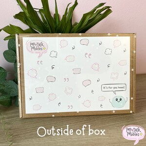 Puede incluir: Una caja de cart&oacute;n marr&oacute;n con una etiqueta blanca. La etiqueta tiene un dise&ntilde;o rosa y blanco con burbujas de di&aacute;logo y el texto "Pep Talk Pebbles". La caja est&aacute; decorada con puntos blancos. El texto "It's for you hooo!" est&aacute; escrito en una burbuja de di&aacute;logo con un personaje de dibujos animados azul dentro.