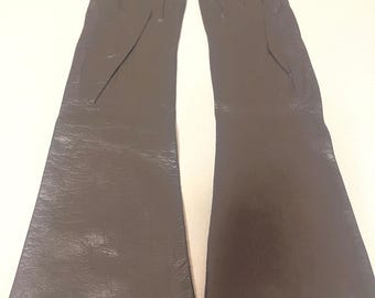 May include: A pair of long, dark gray gloves. The gloves are made of a smooth material and have a classic design. The gloves are laid out flat, showing the full length of the gloves.