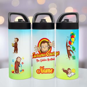 May include: Three insulated water bottles with Curious George designs. Each bottle has a black handle and lid. The bottles show Curious George with balloons, paint, and a book. The bottles have a gradient blue and green background.
