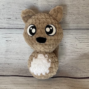 May include: A brown crocheted squirrel plush toy with big black eyes and a white fluffy tail.