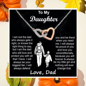 May include: A silver necklace with two interlocking heart pendants, one silver and one rose gold, on a black background. The text reads "To My Daughter" and a message from "Love, Dad" with an illustration of a father and child.