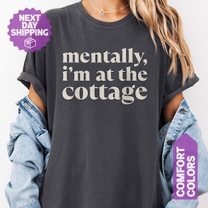Dark heathered unisex tee with retro serif text reading mentally im at the cottage — funny lake life graphic shirt