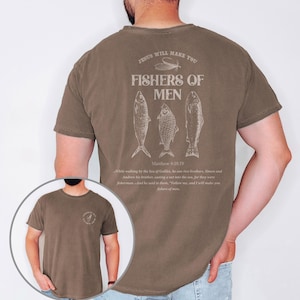 Op de afbeelding: Espresso-kleurig T-shirt met de tekst "JESUS WILL MAKE YOU FISHERS OF MEN" en drie visillustraties. De achterkant van het shirt bevat een citaat uit Matthe&uuml;s 4:18-19. Een kleinere afbeelding van het shirt is linksonder te zien.