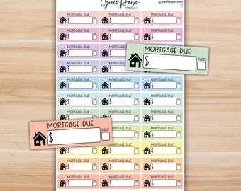 May include: A sheet of rectangular planner stickers featuring the text MORTGAGE DUE, a house icon, a dollar sign, and a checkbox labeled PAID. The stickers come in various pastel colors including pink, purple, blue, green, yellow, and orange.