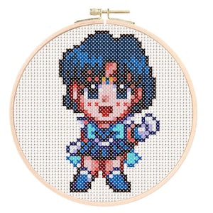 May include: A cross-stitch embroidery hoop with a pixelated image of a blue-haired anime character wearing a blue and white sailor uniform. The character is holding a wand in their right hand.