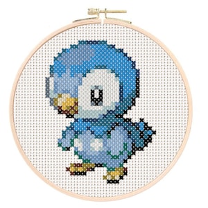 May include: A blue and white cross-stitch embroidery of a cartoon bird in a hoop.