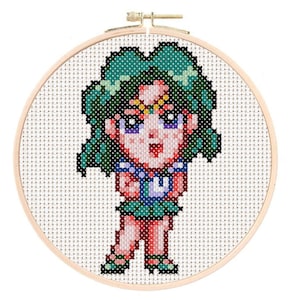 May include: Cross-stitch embroidery of a green-haired anime character with a pink and yellow flower crown, wearing a green and blue sailor uniform. The character is standing with their arms crossed.