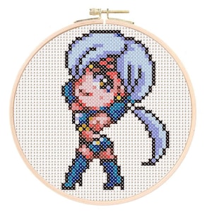 May include: Cross-stitch embroidery hoop with a colorful pixelated image of a female anime character with long purple hair, wearing a blue and red outfit.