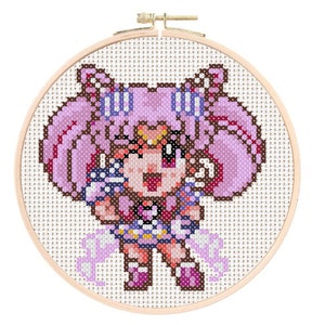 Könnte beinhalten: Kreuzstichmuster eines Anime-Charakters mit rosa Haaren, der eine blaue und weiße Matrosenuniform trägt und einen Zauberstab hält. Der Charakter lächelt und hat einen Stern auf der Stirn.