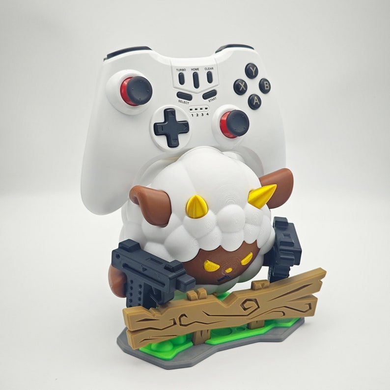May include: A white 3D printed figurine of a sheep holding two guns. The sheep is wearing a brown and yellow hat and has a black face. The sheep is standing on a wooden platform with green grass.