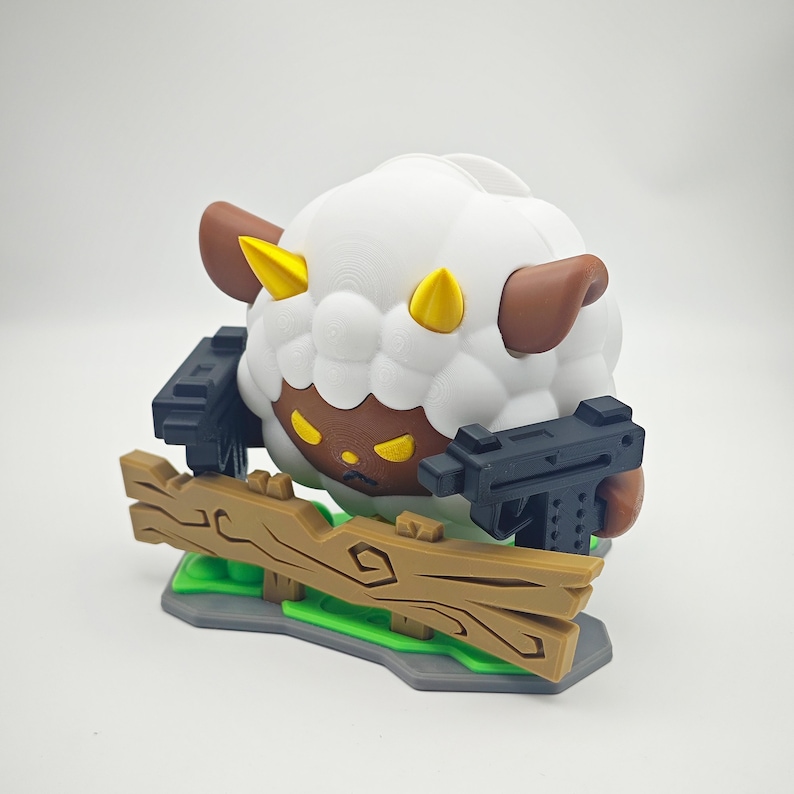 May include: A white sheep with brown ears and horns, holding two black guns, standing on a wooden fence with green grass.