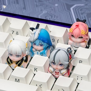 May include: Four miniature anime-style character figurines serving as custom mechanical keyboard keycaps. The figures feature detailed hair, facial expressions, and outfits in white, blue, pink, and grey, positioned between white keys with letters.