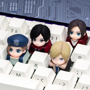 Puede incluir: Primer plano de un teclado blanco con teclas personalizadas que presentan figuras de personajes de estilo anime. Las figuras tienen rasgos faciales detallados y visten diferentes atuendos.