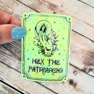 May include: A green holographic sticker with a hand holding a crystal ball and the text "Hex the Patriarchy".