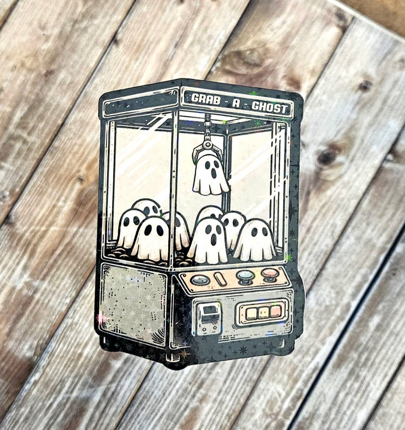 May include: A vintage-style claw machine with the text "Grab-A-Ghost" on the front. The machine is filled with white ghosts with black eyes and mouths.