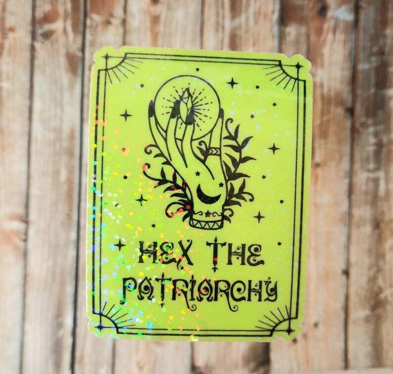 May include: A green sticker with a black and white illustration of a hand holding a crystal ball. The text "HEX THE PATRIARCHY" is printed below the illustration.