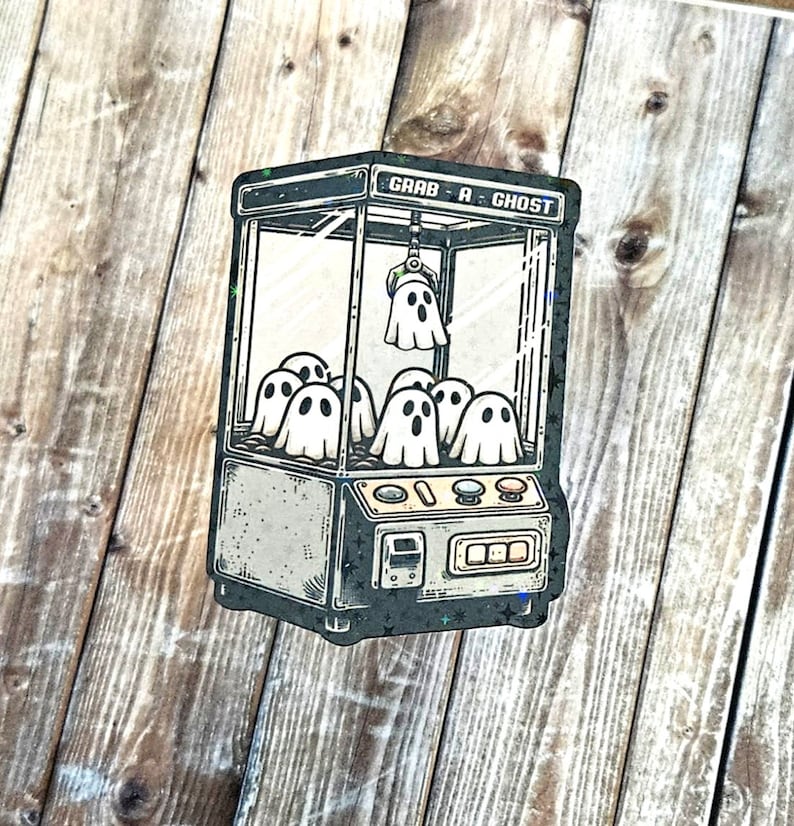 May include: A vintage-style claw machine with the text "Grab A Ghost" on the front. The machine is filled with cartoon ghosts.
