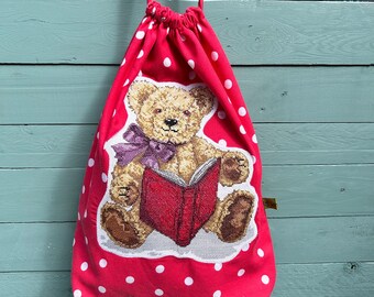 Lined drawstring bag, decorated with a loveable cross stitch teddy bear.  Handmade from upcycled red spotty fabric. Sustainable & Eco.