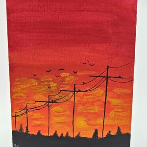 May include: A painting of a sunset with power lines and birds flying in the sky. The sky is painted in shades of red, orange, and yellow. The power lines are black and the birds are silhouetted against the sky. The painting is signed "EK" in the bottom left corner.