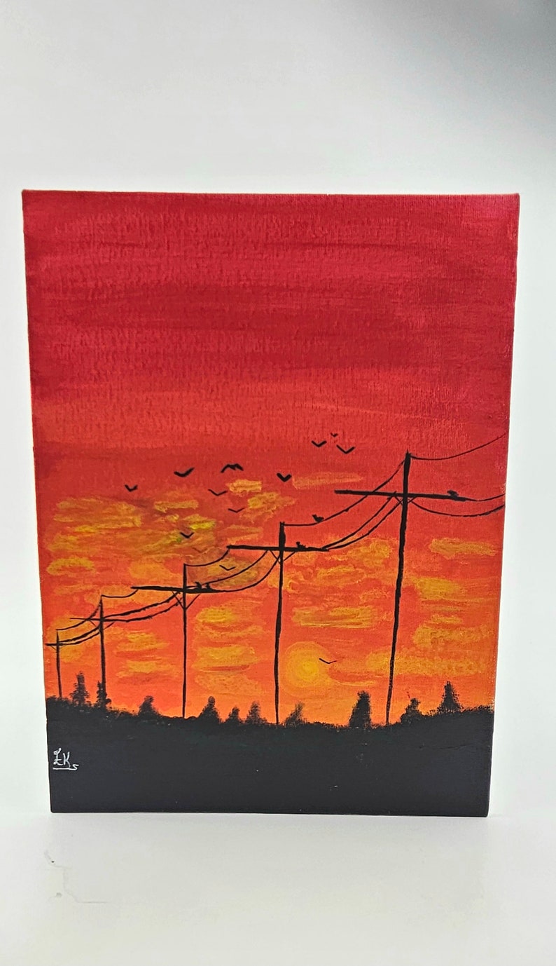 May include: A painting of a sunset with power lines and birds flying in the sky. The sky is painted in shades of red, orange, and yellow. The power lines are black and the birds are silhouetted against the sky. The painting is signed "EK" in the bottom left corner.