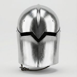 Puede incluir: Un casco plateado pulido con la parte superior redondeada y una abertura para la visera. El casco tiene una superficie lisa y reflectante y una correa para la barbilla. El dise&ntilde;o recuerda a la armadura medieval.