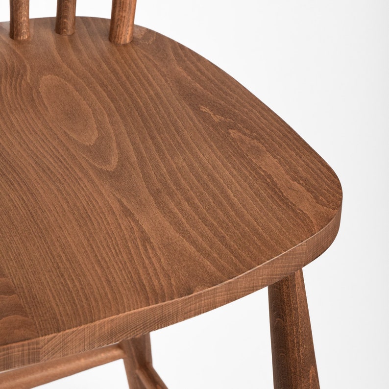 K&ouml;nnte beinhalten: Nahaufnahme der Oberseite eines Holzstuhlsitzes. Der Sitz ist aus hellbraunem Holz mit einer glatten Oberfl&auml;che.