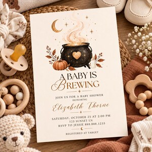 Può includere: Un biglietto d'invito rettangolare per baby shower con un calderone nero con un cuore, una zucca, una luna crescente e stelle. Il testo recita A BABY IS BREWING, JOIN US FOR A BABY SHOWER HONORING Elizabeth Thorne, SATURDAY, OCTOBER 25 AT 2:00 PM, 123 SUNSET LN, RSVP TO JESSIE 888.888.1235, REGISTERED AT TARGET.