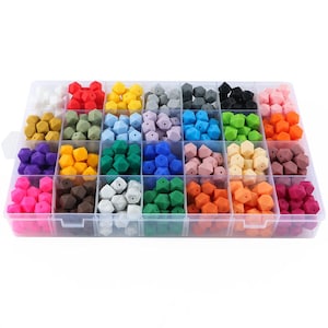 Può includere: Una scatola di contenimento in plastica trasparente piena di perline di silicone colorate. Le perline sono disposte in file e colonne, con ogni fila che contiene un colore diverso. I colori includono rosso, arancione, giallo, verde, blu, viola, rosa, marrone, grigio e bianco.