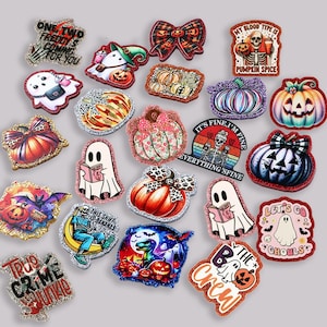 Puede incluir: Una colección de dijes decorativos con temática de Halloween con bordes brillantes. Los diseños incluyen calabazas, fantasmas, lazos y frases como "Pumpkin Spice" y "Let's Go Ghouls". Los dijes presentan varios colores y patrones.