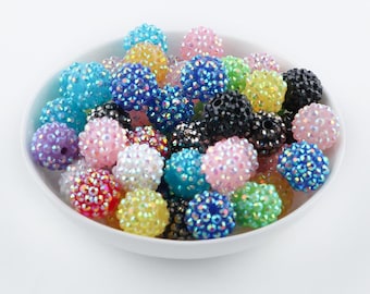 May include: A collection of round, textured beads in a variety of vibrant colours including blue, pink, yellow, green, black, and white. Each bead features a faceted, sparkling surface with a small hole through the centre for threading purposes.