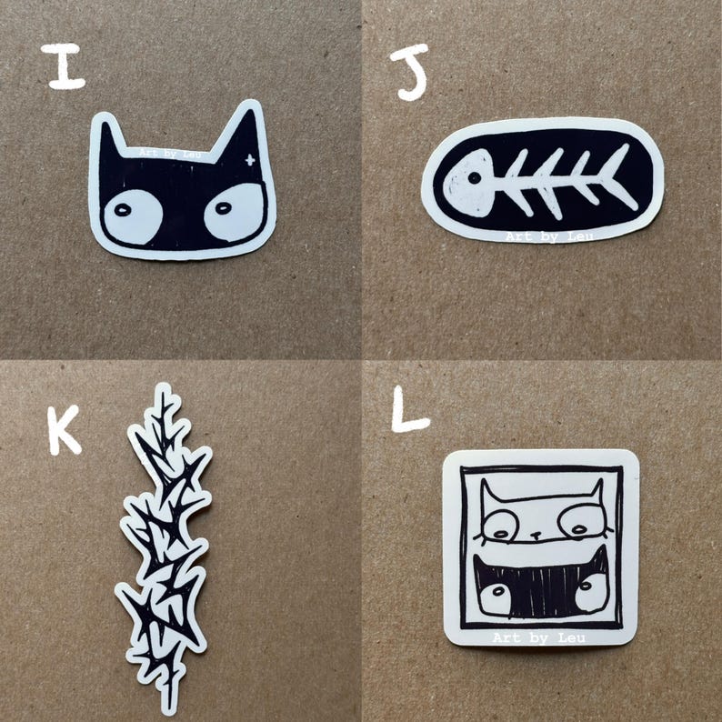 May include: Four black and white stickers on a brown background. The stickers are of a cat, a fish skeleton, a plant, and a cat in a frame. The text "Art by Leu" is on the fish skeleton and cat in a frame stickers.