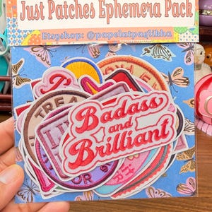 May include: A pack of ephemera patches with the text "Just Patches Ephemera Pack" and the Etsy shop handle. The patches feature various designs, including the words "Badass and Brilliant" in red script.