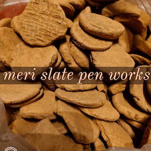 May include: A close-up image of a plastic bag filled with brown clay discs. The text "Punjab ki mitti meri slate pen works" is visible on the bag.