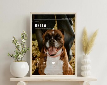 May include: A framed print featuring a brown and white Boxer dog with its tongue out. The print includes the name "BELLA" and the text "BORN ON A MONDAY IN MARCH 2015". The print is displayed on a wooden shelf with decorative vases.