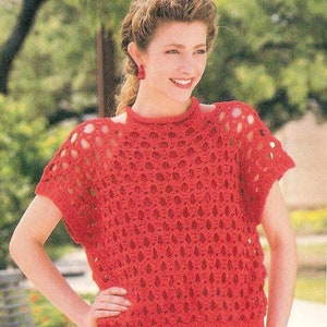 May include: A red crochet top with a lacy pattern and short sleeves. The top has a round neckline and is worn by a model with a ponytail.